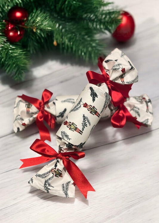 “Two Nutcracker White design cotton luxury Christmas crackers with red bows ”